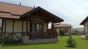 a small house with a porch and a fence at Копа Баварія - Львів Готель in Pasiky-Zubryts'ki