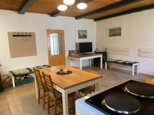 a living room with a wooden table and a kitchen at Stodola v zahradě in Vodňany