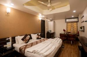 a bedroom with a large bed with a ceiling fan at Hotel Shree Vatika in Bhopal +36 photos