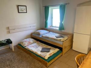 two beds in a room with a window at Stodola v zahradě in Vodňany