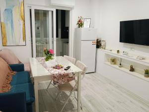 a kitchen and living room with a table and a tv at Apartament Pelicanul in Tulcea