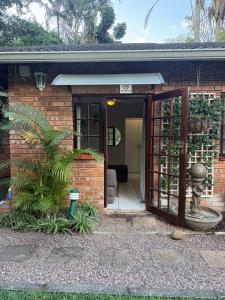 a brick house with a door and a plant at Tranquil Gardens in Pietermaritzburg