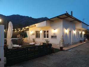 a white house with a patio and a umbrella at la mengola holiday and relax in Trivio