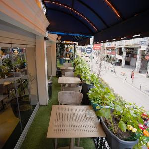 a row of tables and chairs with potted plants at Perada Suite & Room in Istanbul