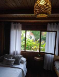 a bedroom with a bed and a window with a chandelier at The Temple III, Mindo in Mindo +27 photos