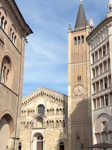 a large building with a clock tower in the middle at Aura Suite in Parma +4 photos