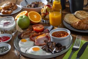 a table with a breakfast plate of eggs bacon and beans at Forest Hills Hotel & Country Club in Frodsham