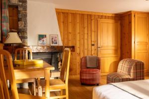 a room with a bed and a table and a fireplace at L'Arveyron Open House in Chamonix
