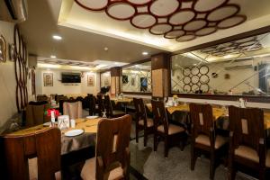 a dining room with tables and chairs in a restaurant at Hotel Shree Vatika in Bhopal