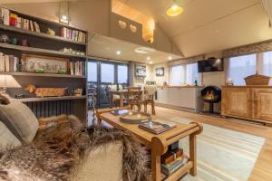 a living room with a table and a fireplace at The Bothy in Ringstead