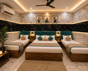 a bedroom with two beds and a blue couch at Hotel Jyoti Stay Inn 2 Min to Ram Tample in Ayodhya