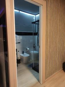 a bathroom with a tub and a toilet and a glass door at la mengola holiday and relax in Trivio