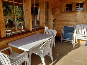 a white table and chairs in front of a cabin at Gemütliche 3 Zimmer Wohnung in Lenzerheide in Lenzerheide +8 photos