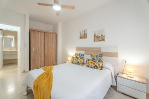a bedroom with a large white bed with pillows at Brisa Caletillas in Punta Larga +15 photos