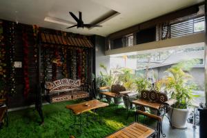 a living room with a couch and tables and plants at Hotel Shree Vatika in Bhopal
