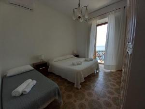 a hotel room with two beds and a balcony at Casa Bettina in Pizzo