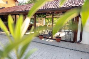 a pavilion with glass doors and potted plants at Casa Mila in Belish