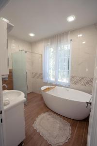 a bathroom with a large white tub and a sink at Casa Mila in Belish +16 photos
