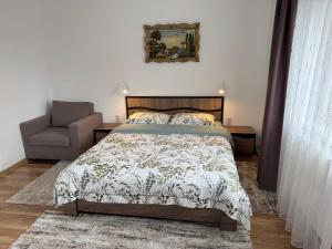 a bedroom with a bed and a chair at Casa Crisan in Topliţa