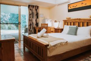 a bedroom with a large bed and a large window at Glasshouse Mountains Ecolodge in Glass House Mountains
