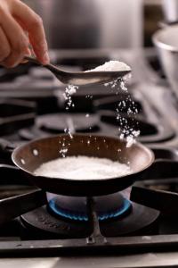 a person is cooking food in a pan on a stove at Picos Hotel in Picos