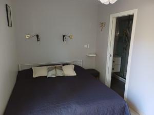 a bedroom with a blue bed with two pillows at Chambres d'hôtes à Raveau in Raveau