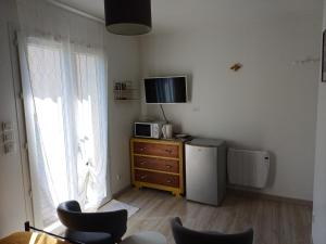 a living room with a television and a dresser with a refrigerator at Chambres d'hôtes à Raveau in Raveau
