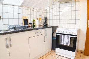 a kitchen with white cabinets and a stove at Le Nid, Duplex lumineux proche Colmar in Soultz-Haut-Rhin +12 photos