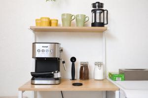 a coffee maker and coffee cups on a counter at Le Nid, Duplex lumineux proche Colmar in Soultz-Haut-Rhin