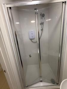 a shower with a glass door in a bathroom at Radstock Road - Room 2 in Southampton