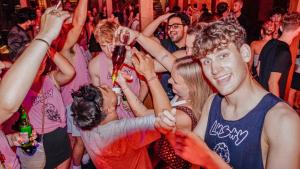 a group of people standing in a crowd at a party at Lushy Hostel Kuta Legian in Legian