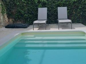 two chairs sitting next to a swimming pool at Casa de las Eras in Valdesimonte