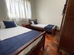 a bedroom with two beds and a window at Casa Jardim Centro in Patos de Minas