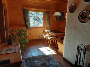 a dining room with a table and a window in a cabin at Gemütliche 3 Zimmer Wohnung in Lenzerheide in Lenzerheide