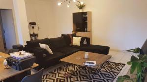 a living room with a black couch and a coffee table at L'Ecrin de l'Abreuvoir in Marnay