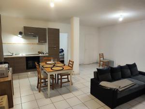 a living room with a couch and a table and a kitchen at L'Ecrin de l'Abreuvoir in Marnay