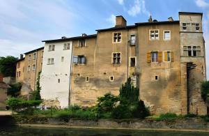 an old building next to a body of water at L'Ecrin de l'Abreuvoir in Marnay