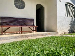 a wooden bench sitting in front of a building at Casa Jardim Centro in Patos de Minas