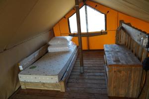 a room with two beds and a bench in a tent at F1 Ardennes Stay 5p Parking Bashfull in Amblève