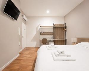 a bedroom with a bed with two towels on it at Foresteria Via Italia - Rooms & Suite in Rho