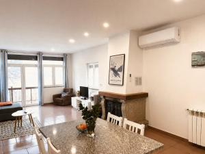 a living room with a table and a fireplace at Casa de Casarelhos - "Gerês" in Geres