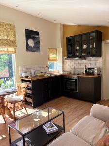 a kitchen with black cabinets and a living room at The Steppes Holiday Cottages in Hereford