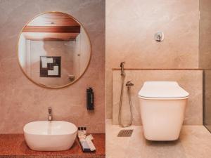 a bathroom with a toilet and a mirror at RaRa Residence in Mumbai