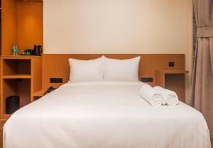 a bedroom with a white bed with towels on it at RaRa Residence in Mumbai +4 photos