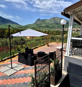 a patio with an umbrella and chairs and mountains at Chalet Ponte Paradiso Suite & SPA in Santa Cristina Gela