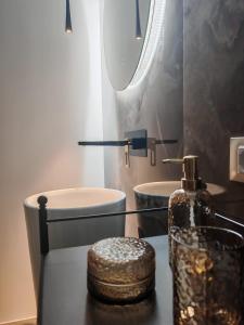 a bathroom with a sink and a bottle on a table at Suite Crystal Home with Jacuzzi in Trapani +4 photos