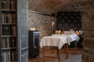 a room with two tables and a fireplace and bookshelves at Tenuta Il Poggio - Luxury B&B in Felegara