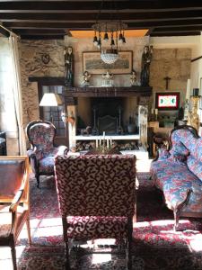 a living room with two chairs and a fireplace at Moulin de Bapaumes in Nérac