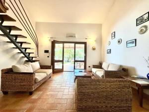 a living room with two couches and a staircase at Le Corti Sarde On The Beach in Bari Sardo +33 photos