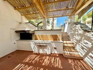 a balcony with stairs and a straw roof at Le Corti Sarde On The Beach in Bari Sardo